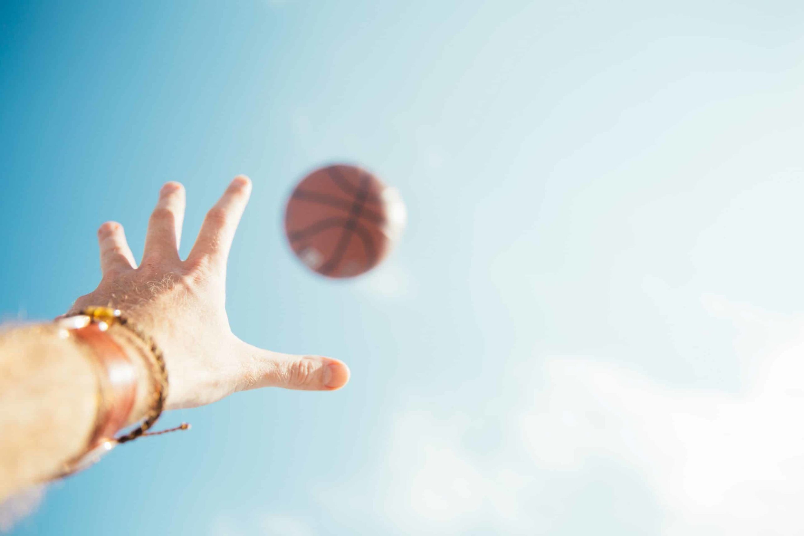 Hand greift nach Basketball in der Luft